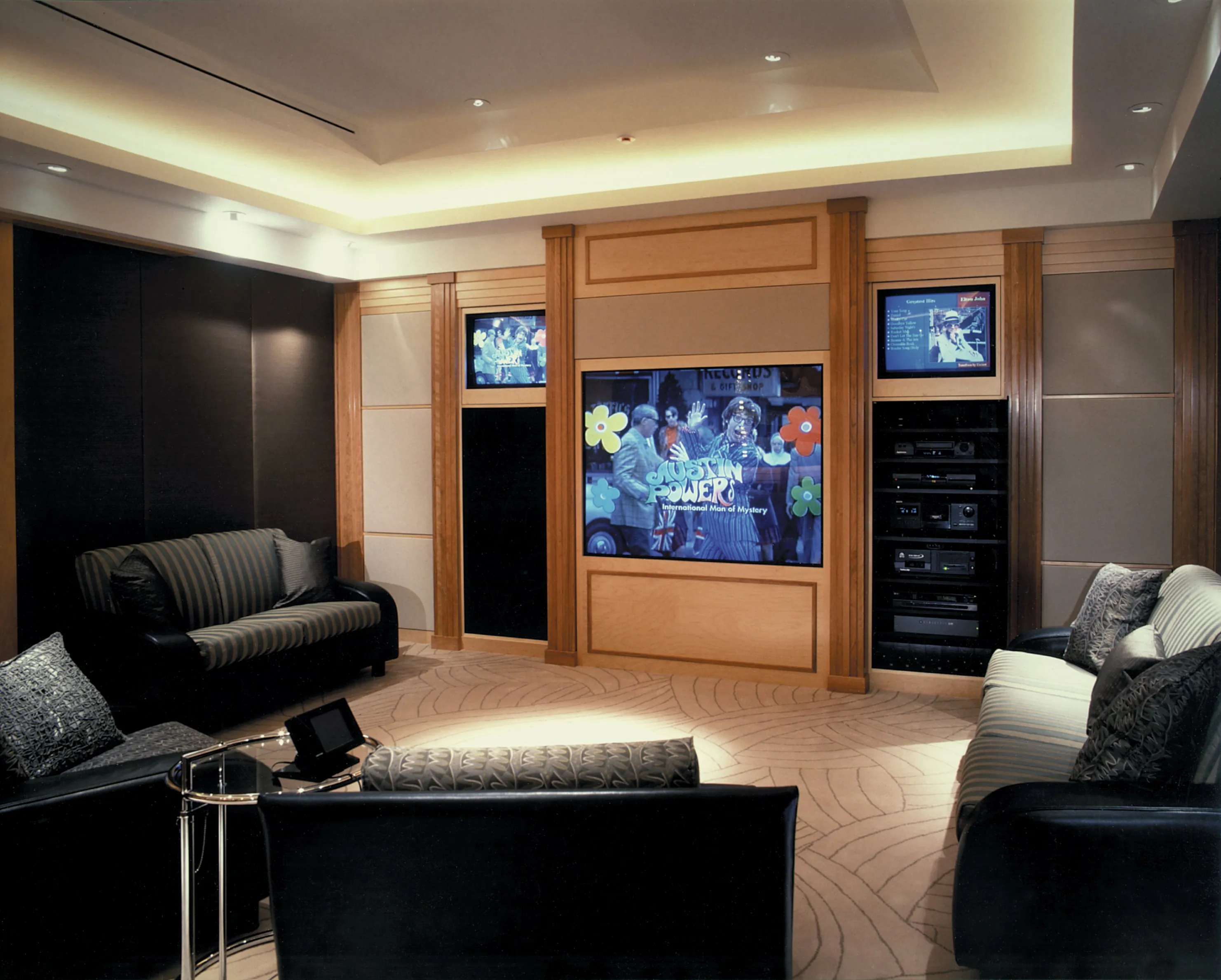 Luxurious home theater with seating, large screen, and audio equipment