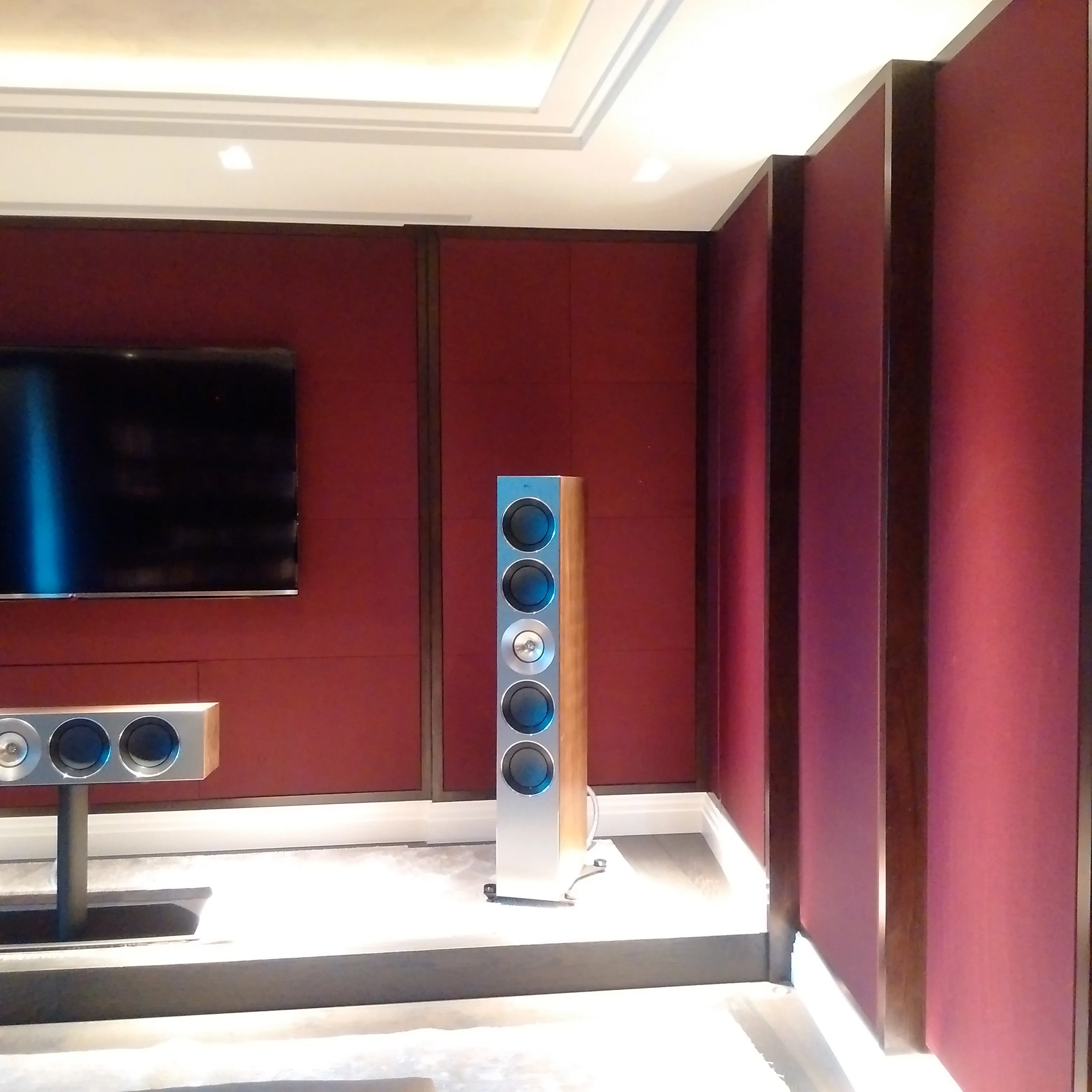 Stylish audio setup with tall speakers and wall-mounted TV in a modern media room