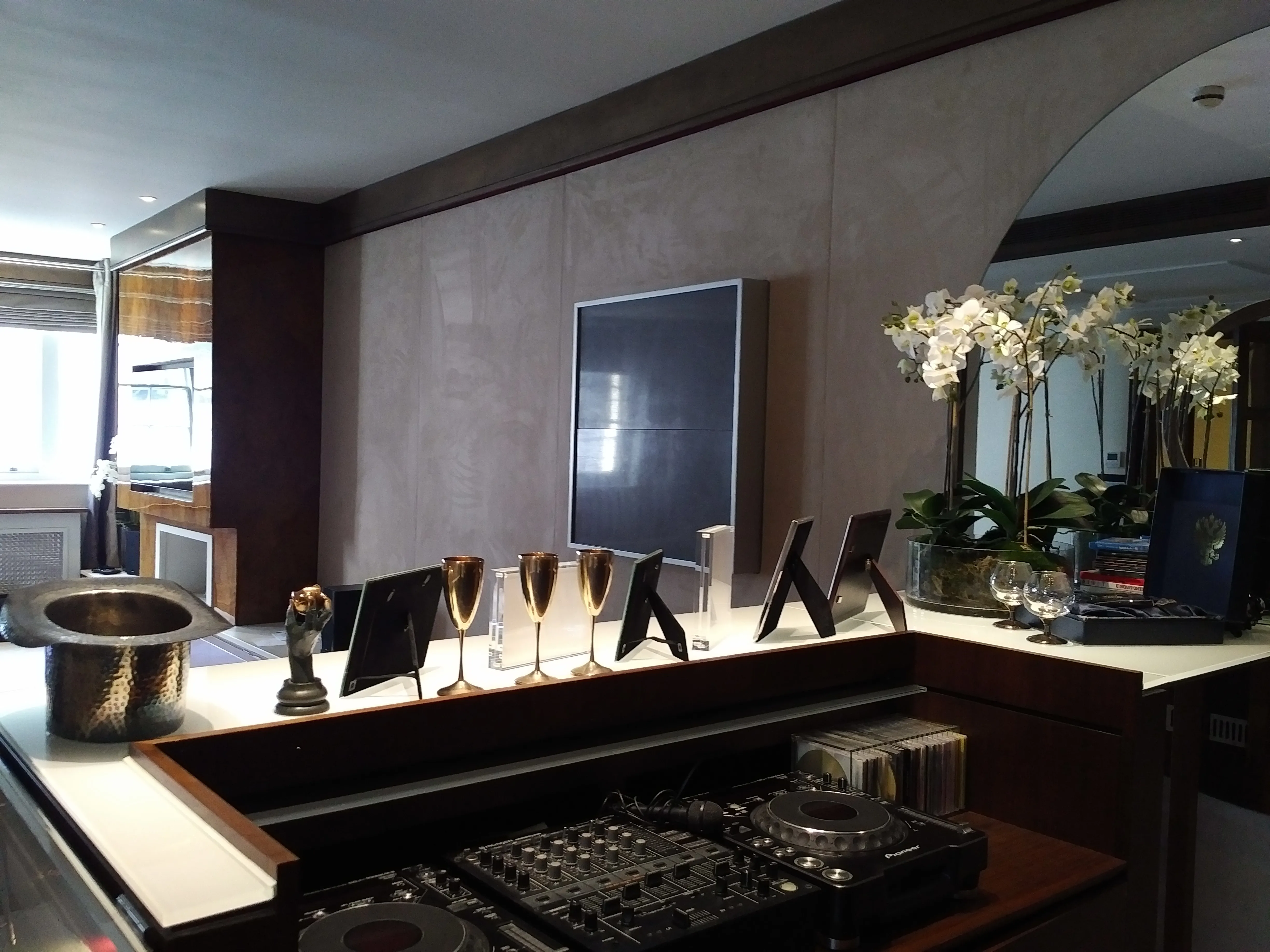 Stylish lounge bar with dark furniture, illuminated walls, and plush seating